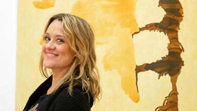 Ein Mann und eine Frau vor einer bunt bemalten Wand.