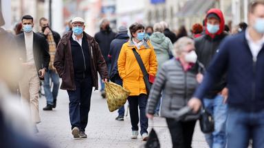 Die nächste Pandemie kommt bestimt:  Menschen mit Masken in einer Fußgängerzone