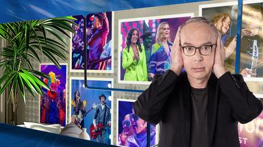 Der Moderator hält sich vor einer Videowand die Ohren zu, auf der Bilder von Musikern zu sehen sind.