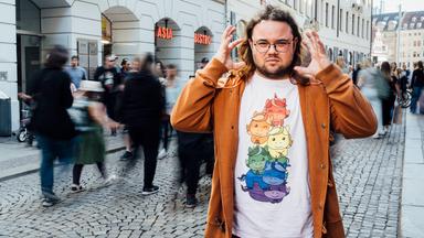 37°Leben: Anders vernetzt – Autismus": Nico-Raphael steht in der belebten Fußgängerzone von Leipzig.