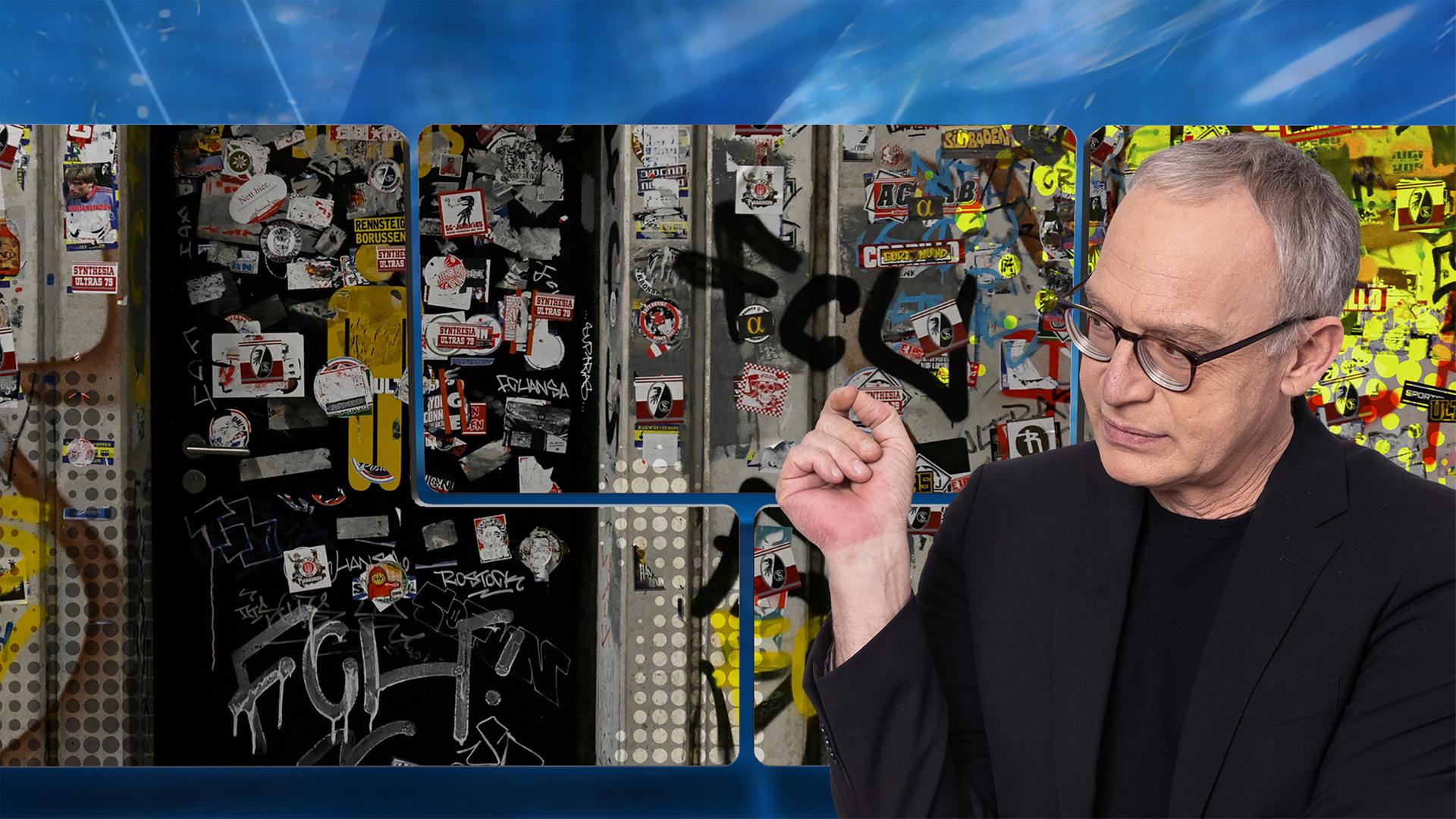 Der Moderator vor einer Videowand, auf der eine Klotür zu sehen ist, die über und über voller Aufkleber und Graffiti von Fußballfans ist.