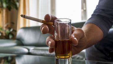 90% der Lungenkrebsfälle sind auf Rauchen zurückzuführen, Alkohol ist ein weiterer Risikofaktor für Krebserkrankungen. (Auf dem Bild zu sehen: Eine Hand, die ein Glas mit Alkohol hält und eine Zigarette)