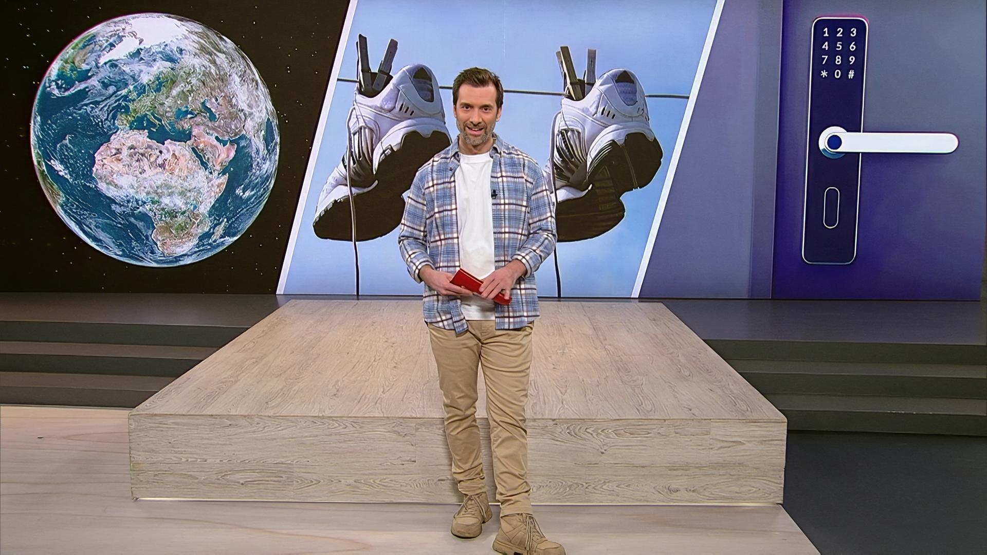 Moderator Daniel Aßmann steht während seiner Moderation im Servicezeit Studio.