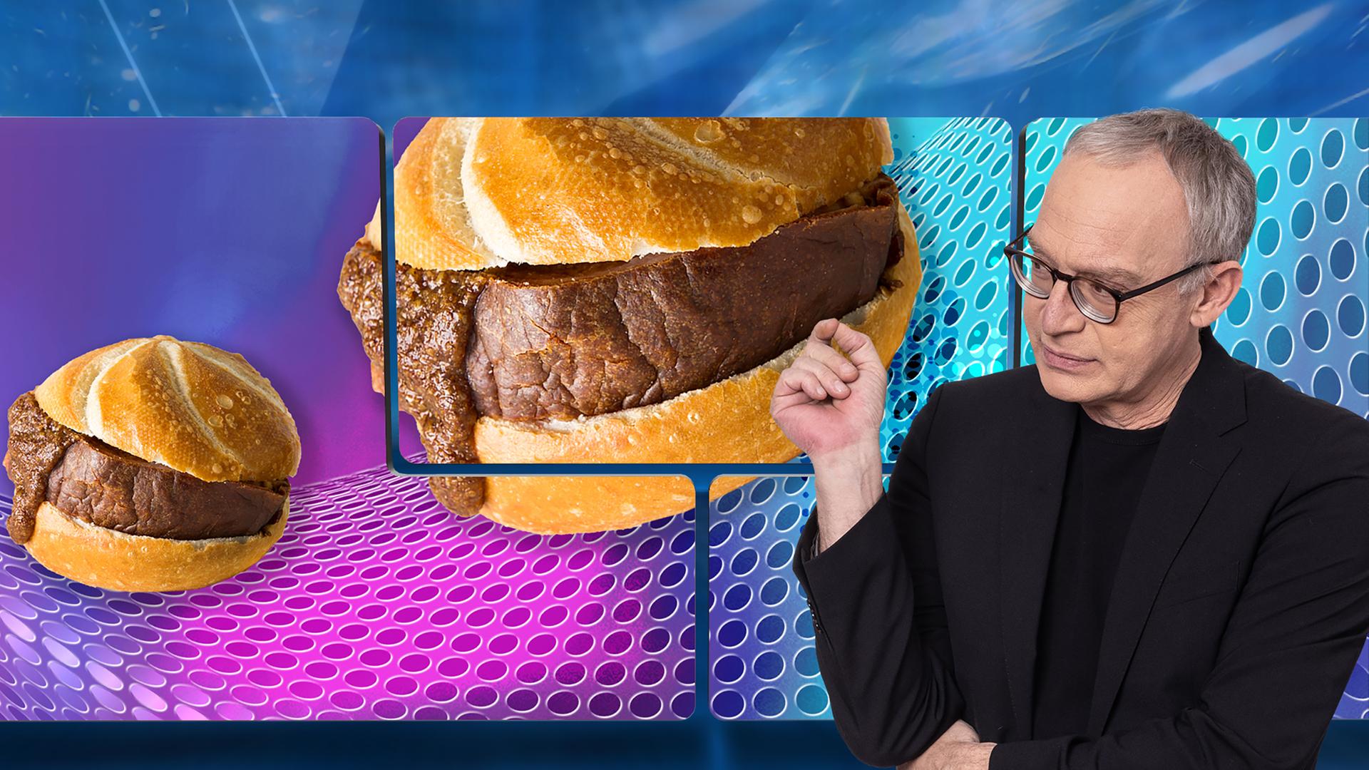 Der Moderator Christoph Süß steht vor einem Bild mit Leberkässemmeln.