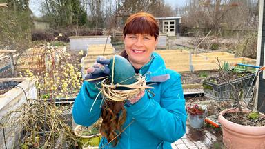 Sabrina Nitsche hält ein Osternest in der Hand. Sie hat das Nest aus den Ranken der Waldrebe geflochten und in die Mitte ein türkisfarbenes Emu-Ei gestellt.