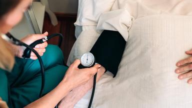 In Schweizer Praxen übernehmen Pflegeexpert:innen ausgewählte ärztliche Tätigkeiten. Können sie so die medizinische Versorgung auf dem Land sichern? (Bild: Pflegeexpertin misst Blutdtuck)