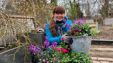 Sabrina Nitsche im Garten zwischen Pflanzen.