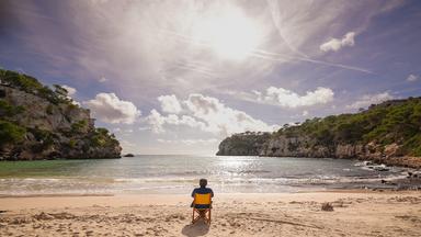 Schmidt Max sitzt auf einem Klappstuhl und schaut aufs Meer hinaus