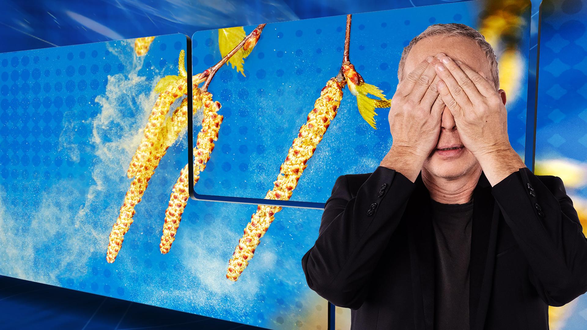 Der Moderator Christoph Süß steht vor einem Bild mit Blütenpollen und hält sich die Hände vor die Augen.