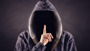 Ausländischen Geheimdiensten rekrutieren über Chats Laien-Spione als Wegwerf-Agenten. Wer scheinbar banale Aufträge annimmt, riskiert Jahre im Knast. (Bild: Mann mit Kaputze, im Dunkeln)