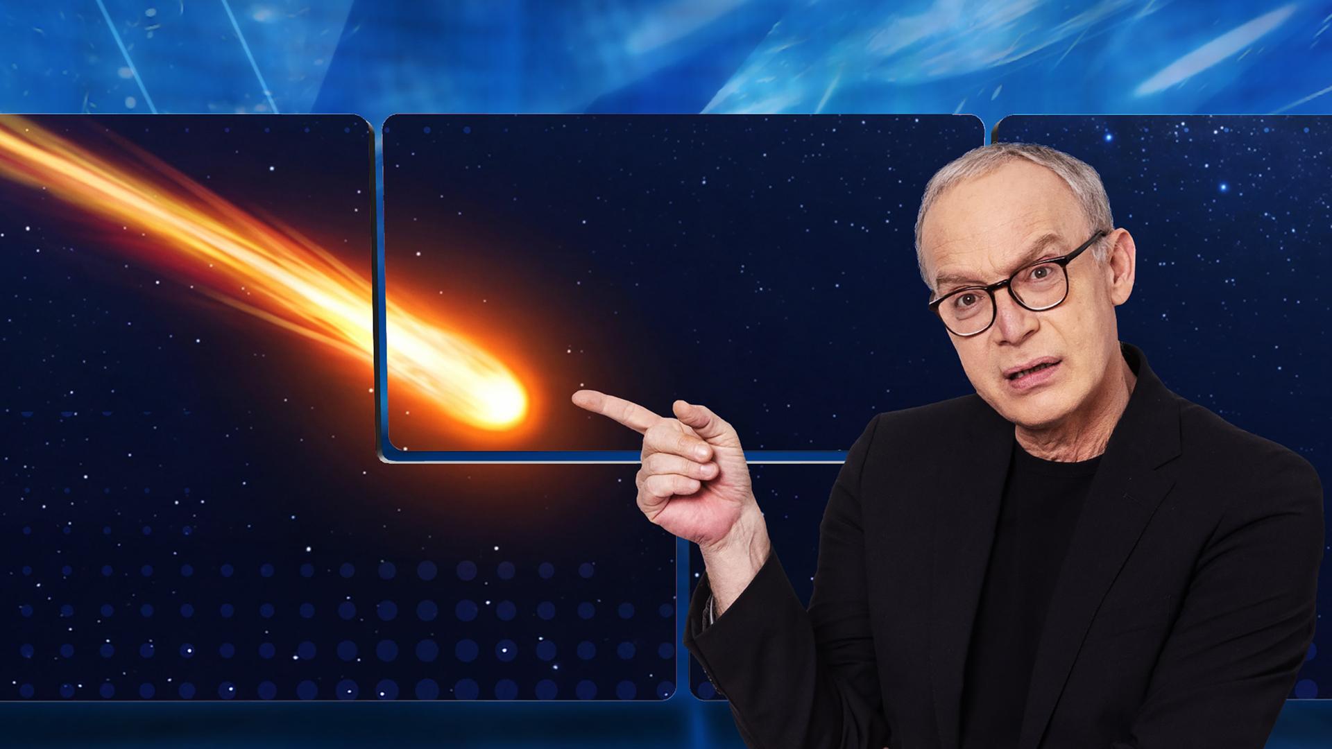Christoph Süß vor einer Videowand, auf der ein Meteorit zu sehen ist, der über den Sternenhimmel rast.