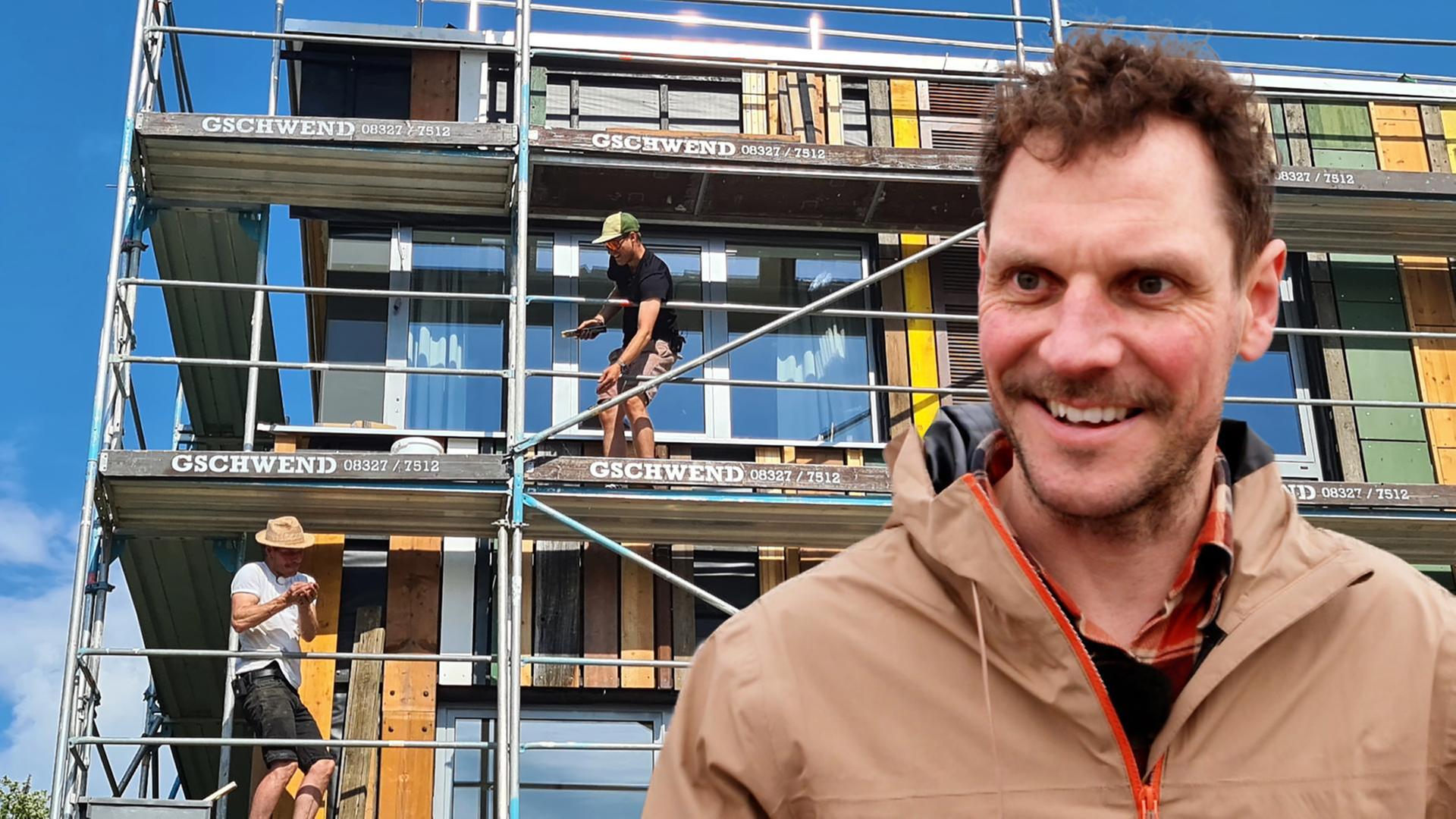 Der Architekt Till Lill von Supertecture - im Hintergrund ein Haus mit Baugerüst, auf dem Arbeiter zu sehen sind.