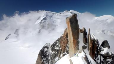 Der Felsturm Arêt des Cosmiques unterhalb der Aiguille du Midi, Chamonix. Im Hintergrund der Mont Blanc