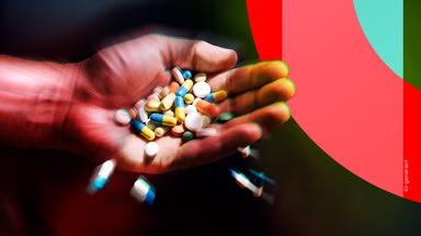 In einer Hand liegen viele verschiedenfarbene Tabletten