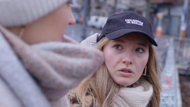 Junge Ukrainerin, das Gesicht ist groß, die eine Mütze mit Aufschrift trägt