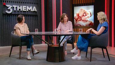 Drei Frauen sitzen im Studio an einem Tisch.