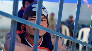 Ein Mann blickt durch Gitterstäbe.