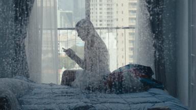 Frau im Profil durch die Duschwand gefilmt.