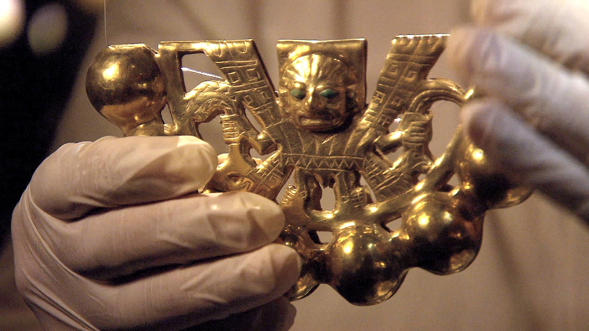 Zwei Hände halten einen goldenen Leuchter 