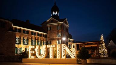Ein beleuchtetes Schloss im Schnee.