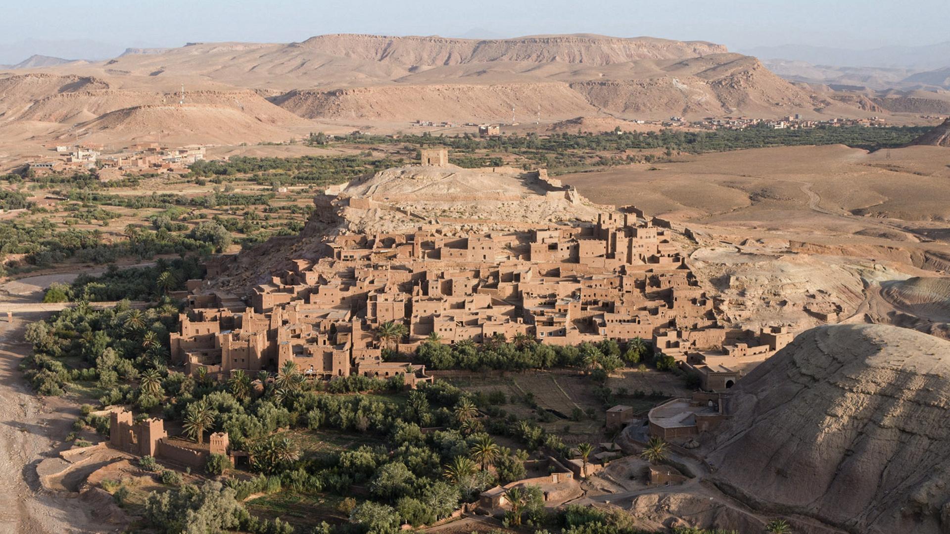 Blick von oben auf erdfarbene Bergsiedlung, die sich farblich kaum von der Natur abheben.