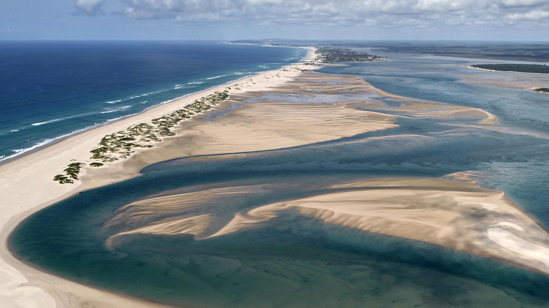 Dünenlandschaft mit Wasserläufen aus der Vogelperspektive.