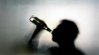 Mann trinkt aus einer Flasche.