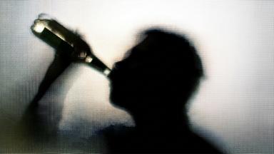 Mann trinkt aus einer Flasche.