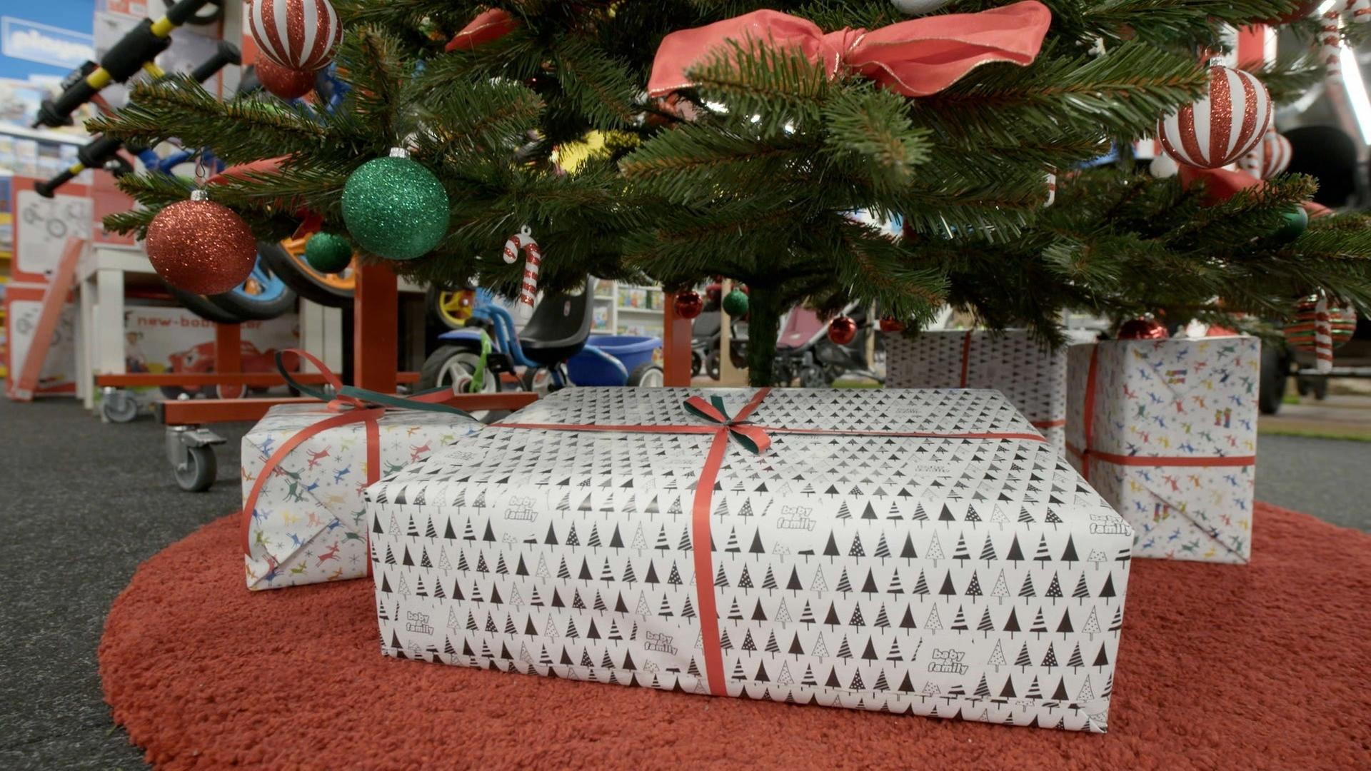 Geschenke unter einem Plastikbaum.