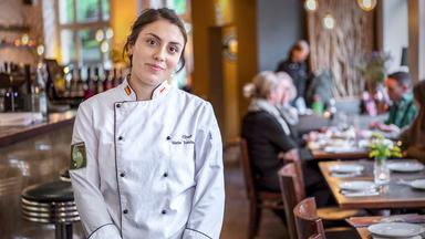 Eine junge Frau in einer Kochjacke.