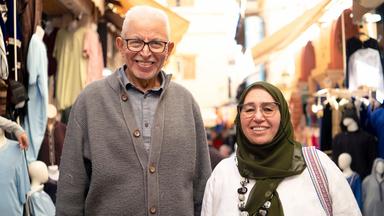 Ein Mann und eine Frau vor dem Hintergrund eines marokkanischen Markts.