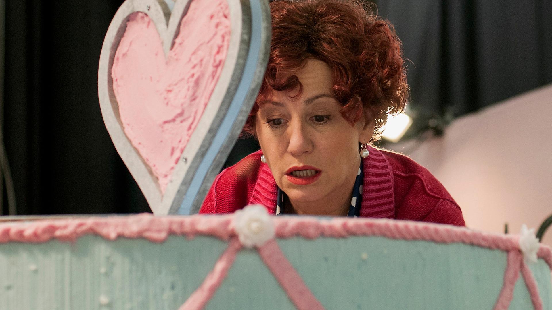 Herta Frohwitter (Ulrike Krumbiegel)  in einer übergroßen Torte.