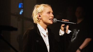Alli Neumann singt in ein Mikrofon.