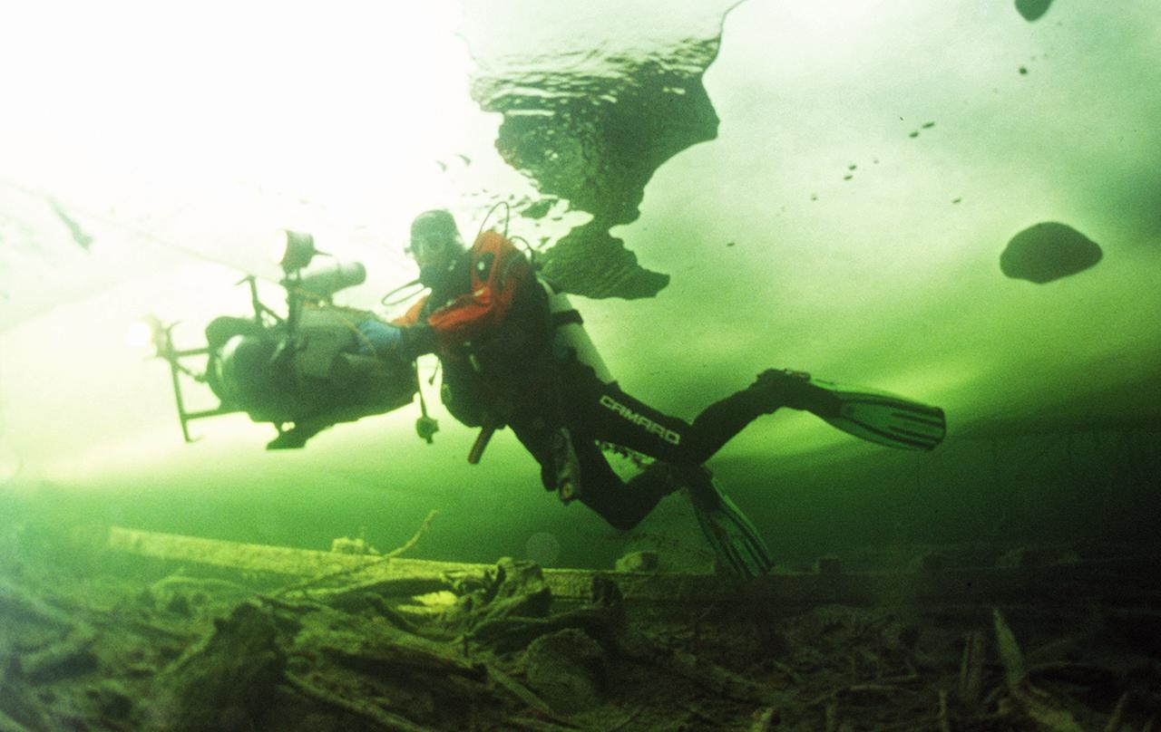 Ein Taucher unter der vereisten Oberfläche eines Sees