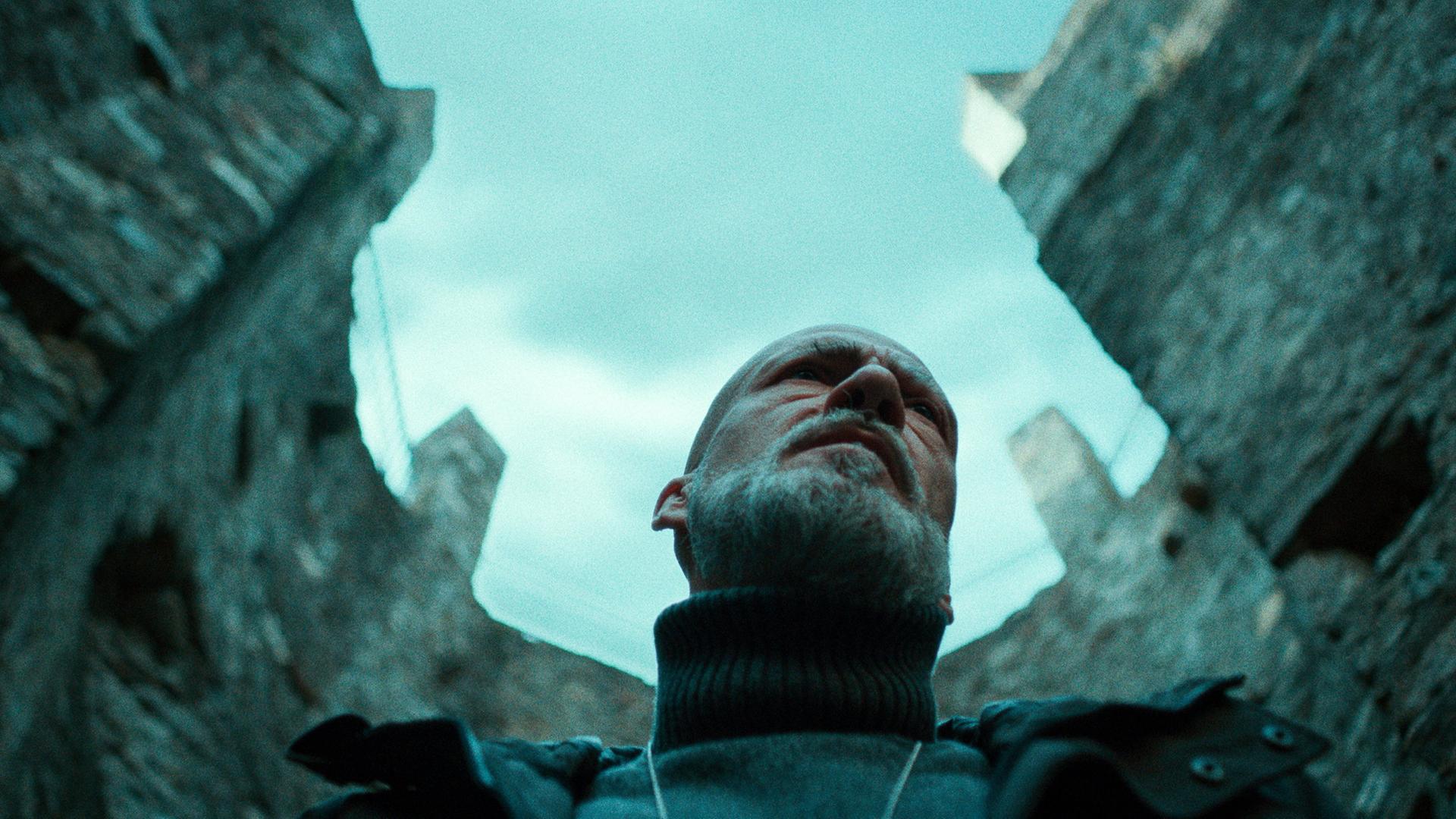 Kommissar Leonardo Blum, gespielt von Gian Marco Tognazzi, steht am Fundort einer Leiche in einem düsteren Außenbereich.