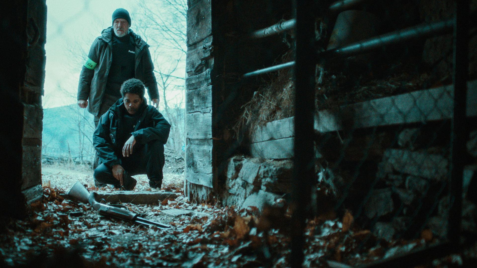 Kommissar Leonardo Blum (Gian Marco Tognazzi) steht über einer Blutspur, während Samuel Donati (Marcos Piacentini) im Hintergrund zu sehen ist.