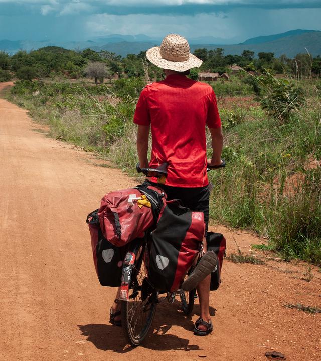 Anselm Nathanael Pahnke von hinten auf Fahrrad. Er blickt in die Landschaft.