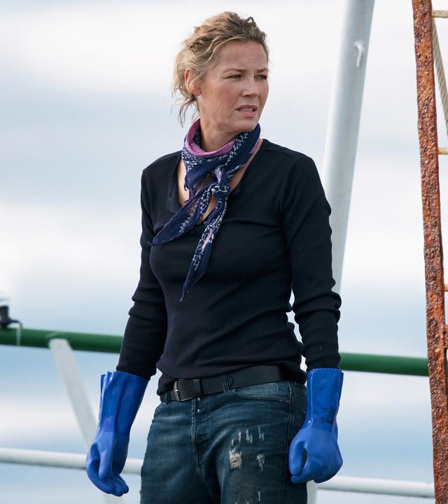 Freya (Connie Nielsen) steht auf dem Deck. Sie trägt blaue Plastikhandschuhe.