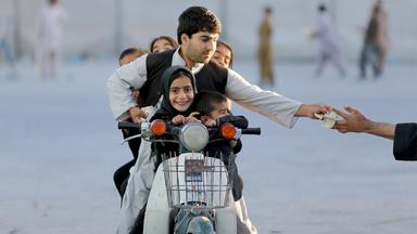 "Anja Niedringhaus - Die Fotografin und der Krieg": Kandahar, Afghanistan, 2013: Ein Vater bezahlt Eintritt für einen Vergnügungspark.