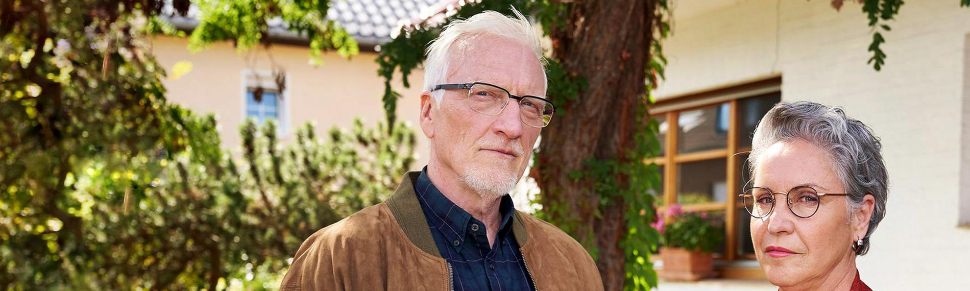 Ein Mann und eine Frau vor einem Haus.
