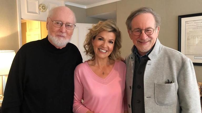 John Williams, Anne-Sophie Mutter und Steven Spielberg stehen nebeneinander und lächeln in die Kamera.