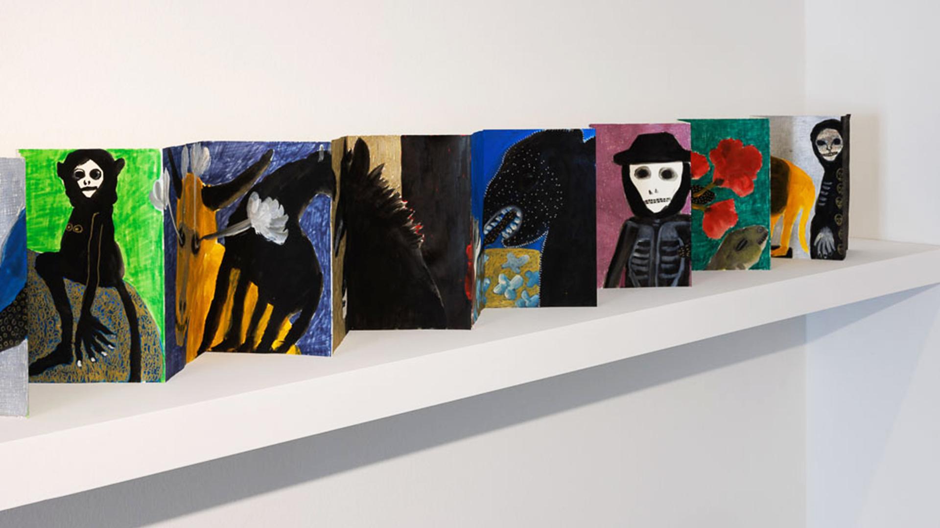 Leporello mit kleinen Gemälden von Figuren und Tieren