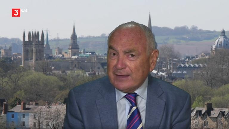 Mann in Anzug vor der Skyline von Oxford.