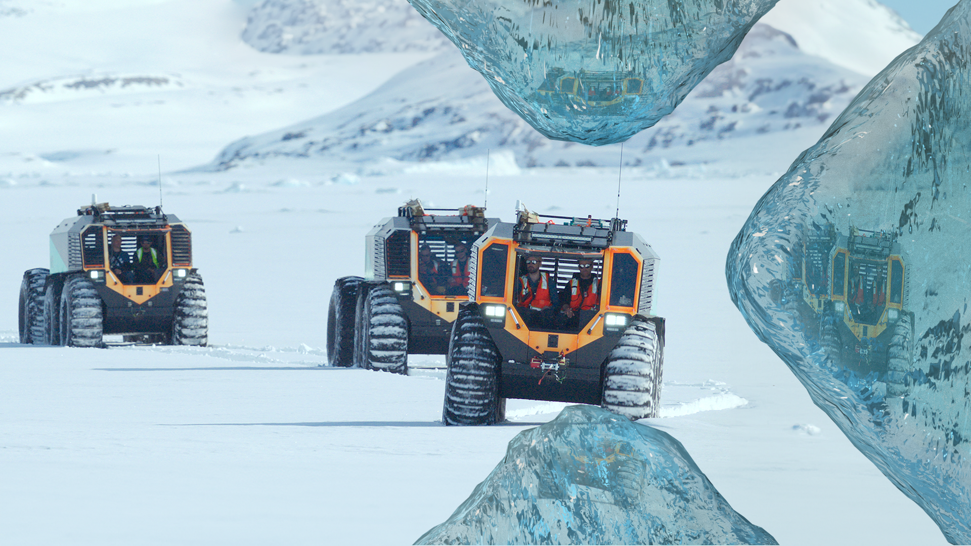 Drei große Schneefahrzeuge fahren hintereinander in einer schneebedeckten Landschaft.