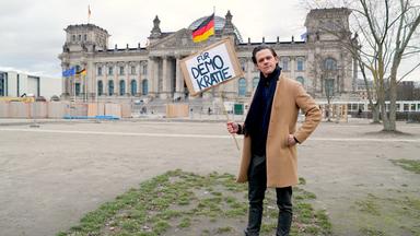 aspekte-Moderator Jo Schück mit Demokratieschild vor Reichstag