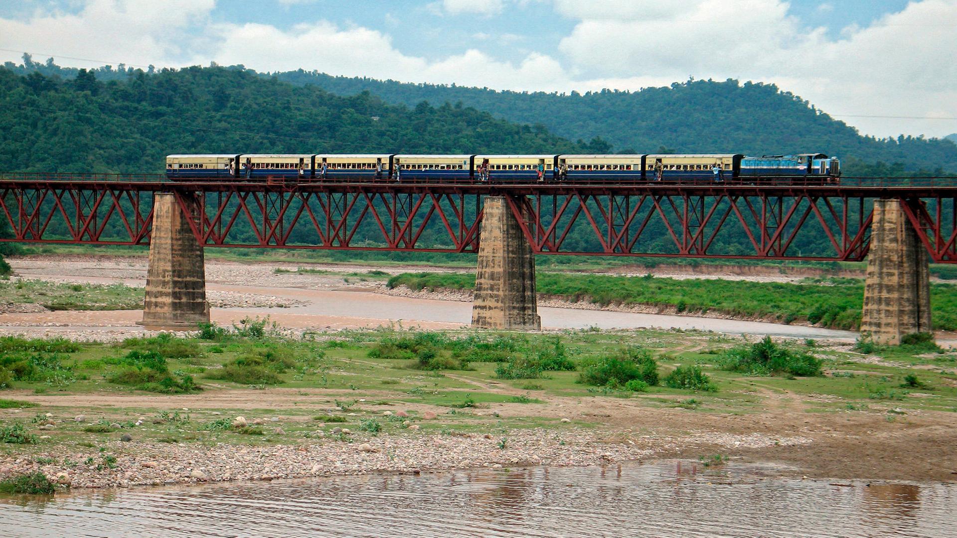 Ein Zug auf einer Brücke über einen Fluss.