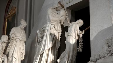 Canova-Denkmal in der Augustinerkirche in Wien. Dargestellt sind mehrere Figuren aus weißem Marmor, die tief in eine szenische Darstellung involviert sind. 