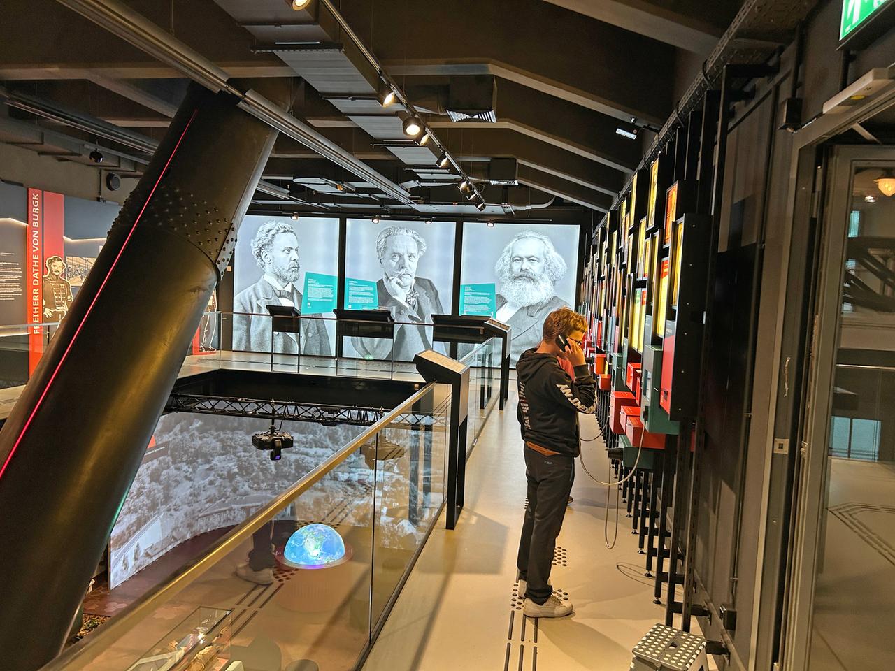 Ausstellungshalle - Ein Junge hört sich ein Audiofile an einem Gerät an