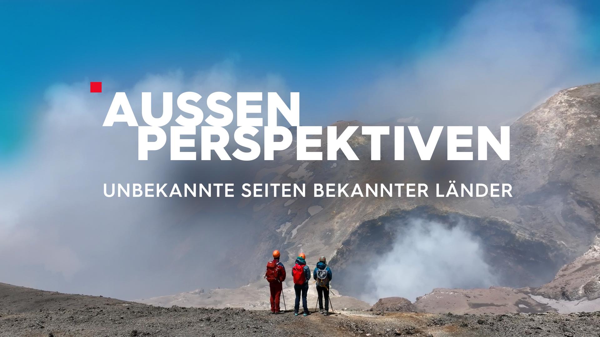 3 Bergsteiger blicken auf eine Bergkulisse, Wolken