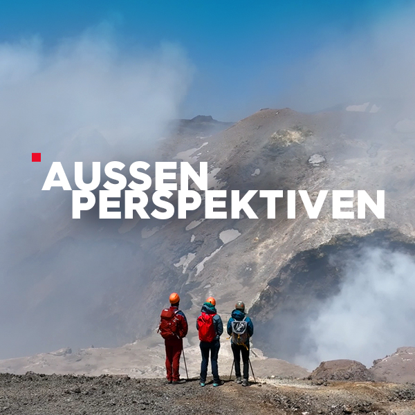 3 Bergsteiger blicken auf eine Bergkulisse, Wolken